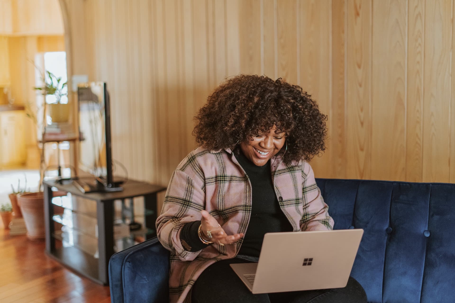 A woman sitting on a couch doing a virtual interview on her laptop