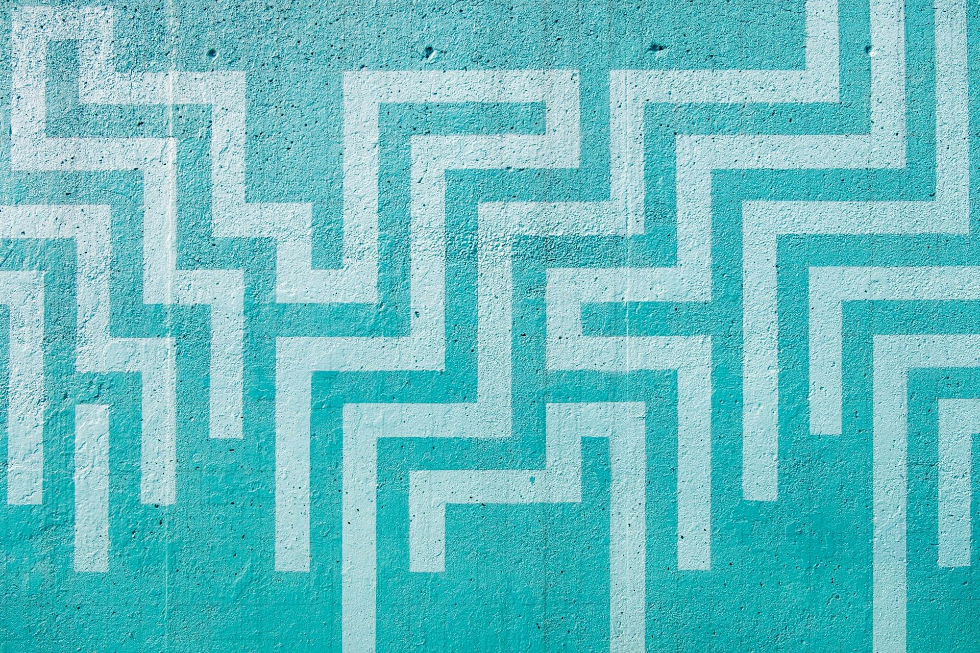 A blue wall with a white maze painted onto it